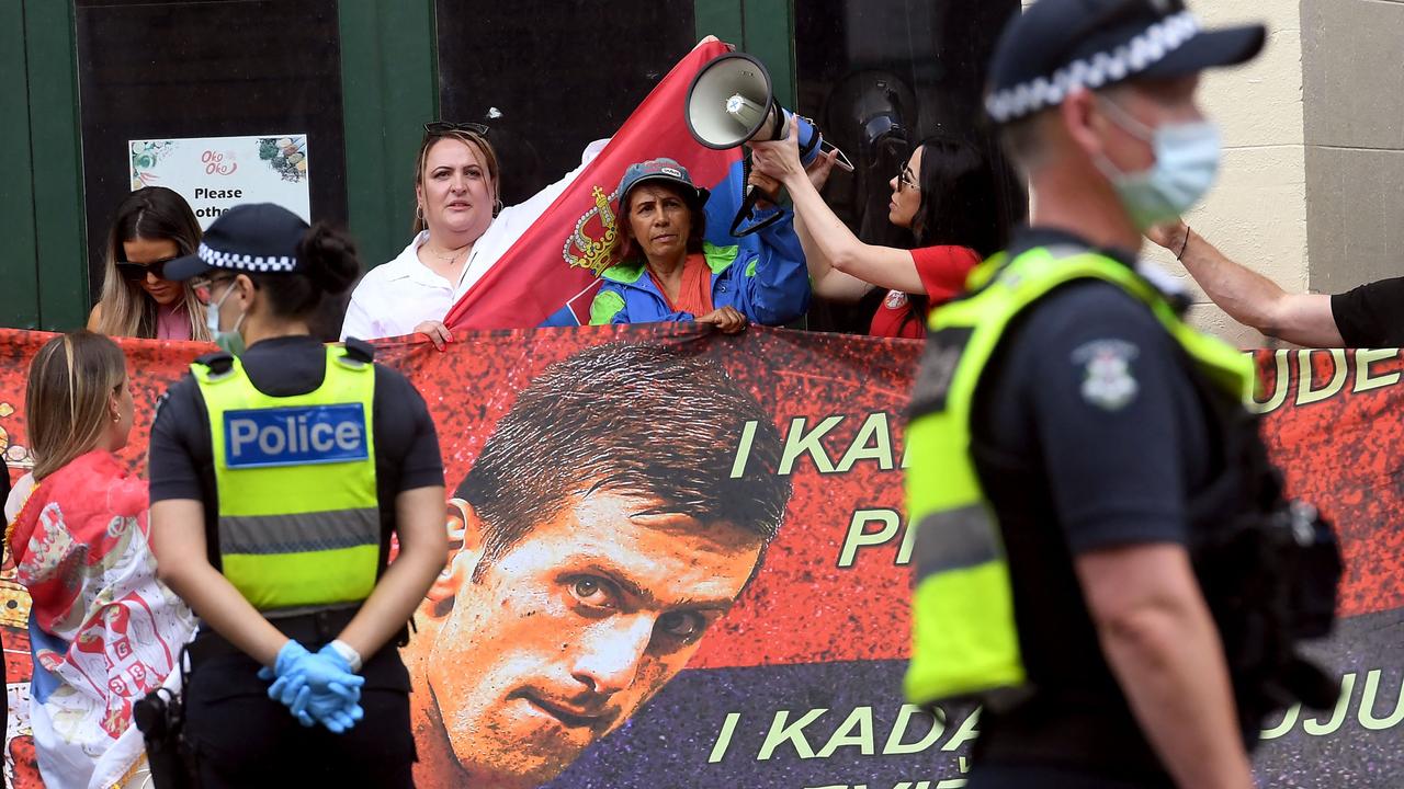 Protesters hold placards up outside the Melbourne detention centre Djokovic is currently in. Picture: William West/AFP