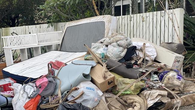 Ruined household goods pile up at Machans Beach with the clean up underway in December. Picture: Bronwyn Farr