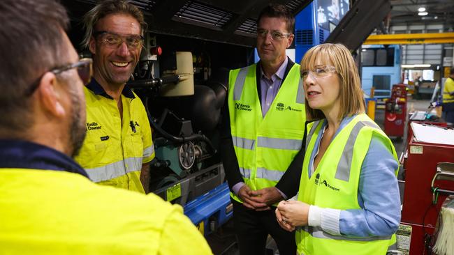 The NSW Transport Minister Jo Haylen and independent MP for Wakehurst, Michael Regan, speak with mechanic apprentice Brad Walker and other employees at the workshop in the Keolis Downer bus depot at Brookvale on Friday. Picture: NSW Government