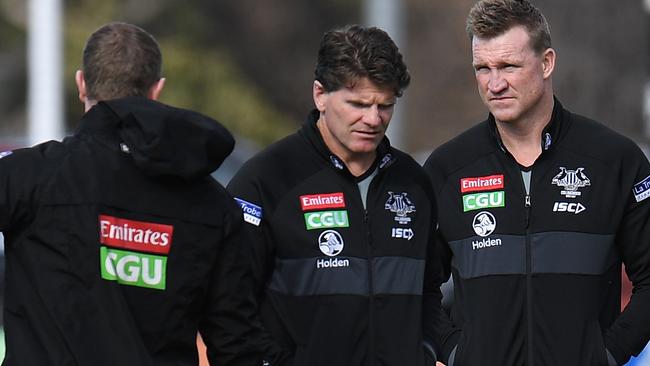 Collingwood assistant coaches Scott Burns and Robert Harvey chat with senior coach Nathan Buckley at training this week. Picture: AAP