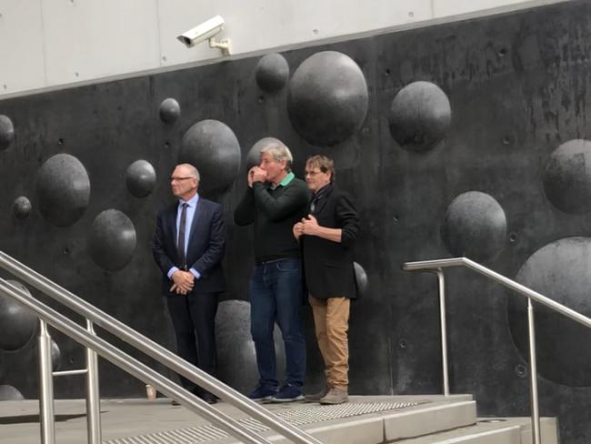 Child sex abuse survivor Paul Gray (middle) booed and hurled abuse at Archbishop of Adelaide as he left court on Tuesday.