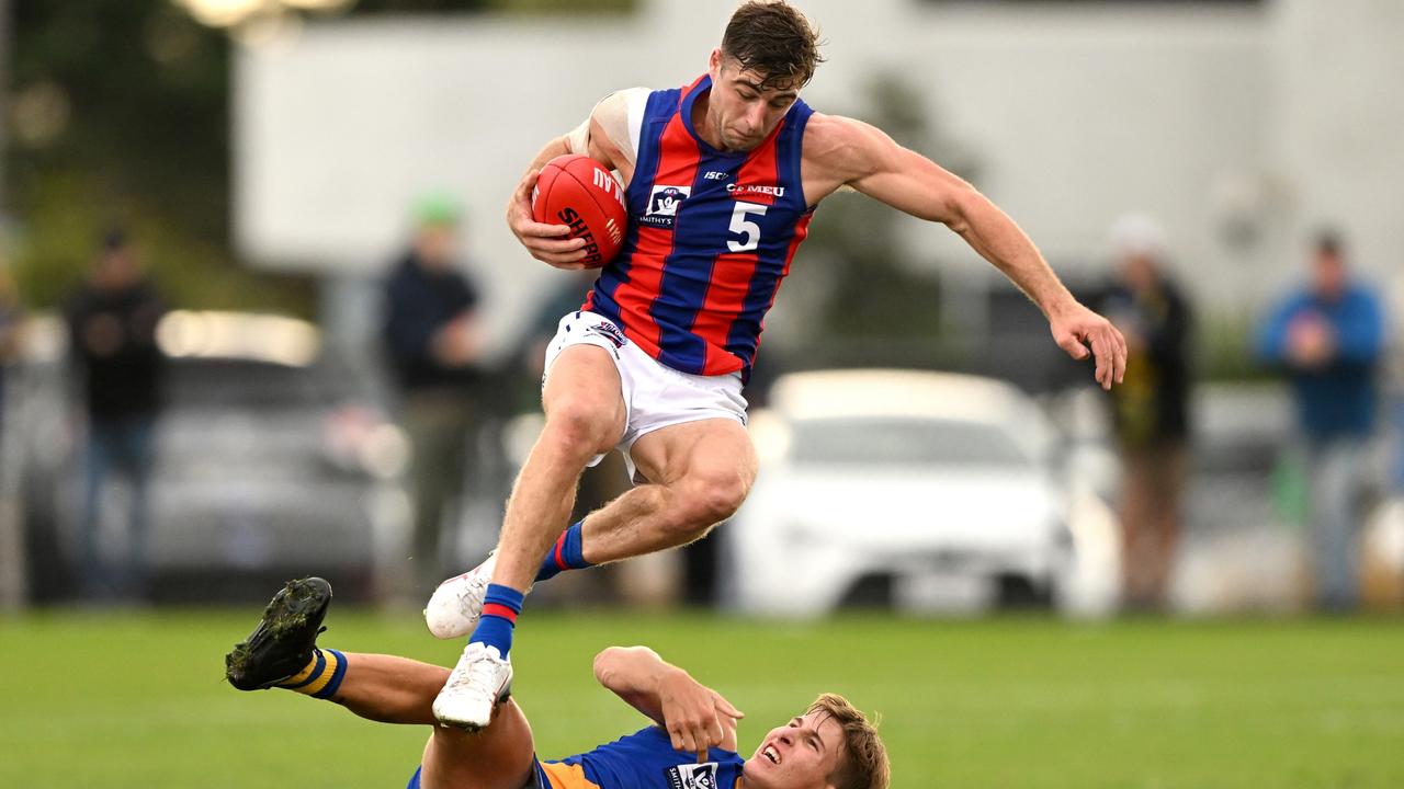 Nash Holmes, in action for Port Melbourne, hurdles Williamstown’s Toby Triffett.