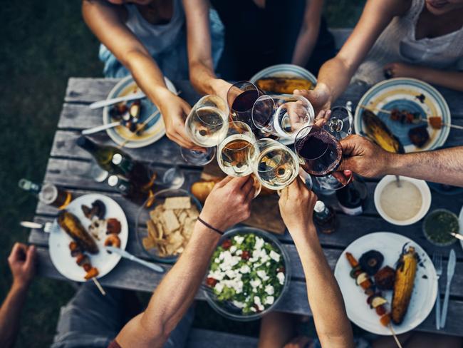 Shot of a group of friends making a toast over dinner