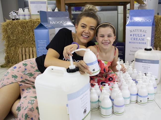 Shae Baker helps Annabelle Worrell, 6, refill her skin care container.