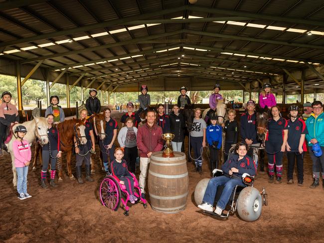 Damien Oliver poses with the 2019 Melbourne Cup with volunteers, riders and students at the Claremont Therapeutic Riding Centre in Perth. Picture: Paul Kane