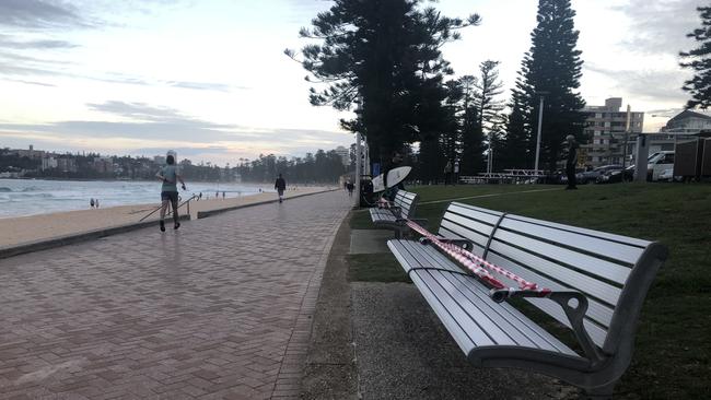 Benches along Manly seafront taped up due to COVID-19 social distancing rules ahead of the long Easter weekend. Picture: Julie Cross