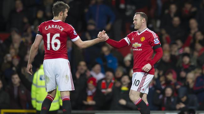 Manchester United's Wayne Rooney, right, shakes hands with teammate Michael Carrick after scoring during the English Premier League soccer match between Manchester United and Stoke at Old Trafford Stadium, Manchester, England, Tuesday, Feb. 2, 2016. (AP Photo/Jon Super)