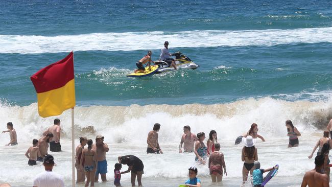 Lifeguards at Surfers Paradise beach keep an eye on beachgoers and keep them swimming between the flags on one of the busiest days of the year. Picture: Glenn Hampson