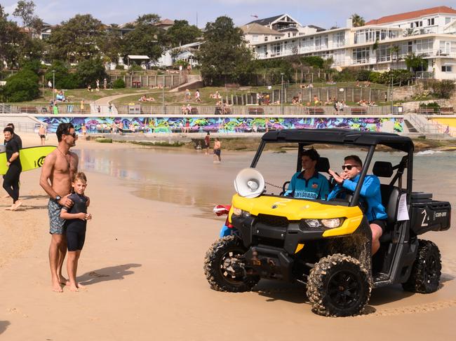 Lifeguards direct beachgoers after the closure of Bondi Beach this afternoon in Sydney, Saturday, March 21, 2020. Picture: James Gourley