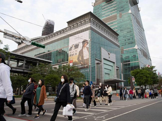 People walk along the street next to the Taipei 101 building in Taipei on Sunday as China launched military drills around Taiwan. Picture: AFP