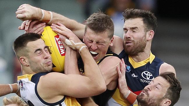 Glenelg’s Luke Reynolds, second from left, gets sandwiched in a pack by Crows players Myles Poholke, Andy Otten and Matthew Wright. Picture SARAH REED