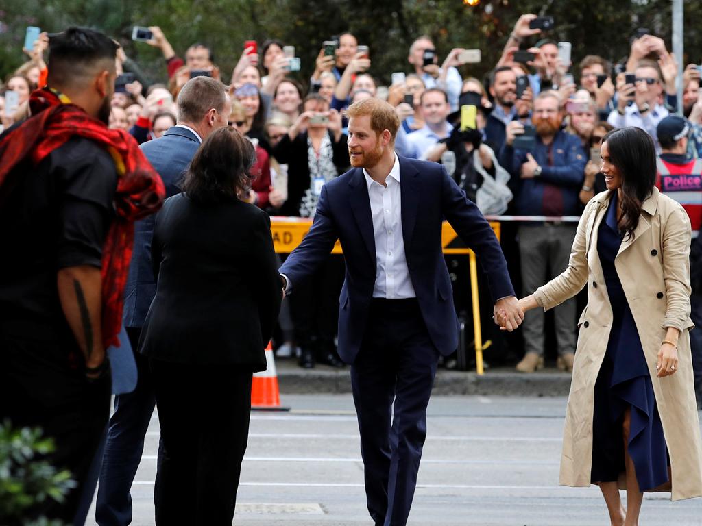The couple greeted the painter of a mural they saw near the Mission Australia social enterprise restaurant Charcoal Lane, but not the hundreds of disappointed fans. Picture: Phil Noble