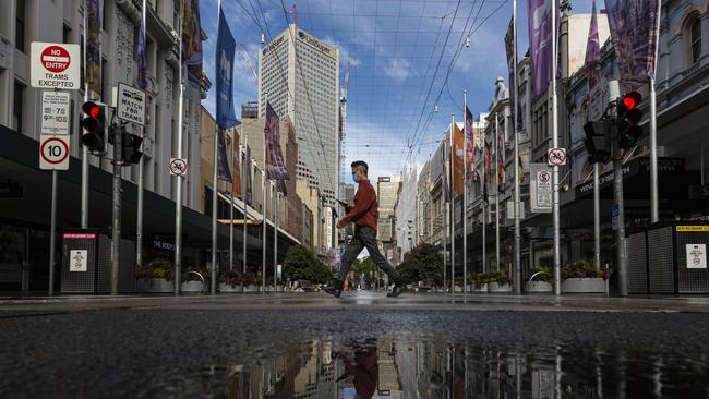 A person crosses a quiet Bourke Street in Melbourne. Picture: Daniel Pockett/NCA NewsWire.