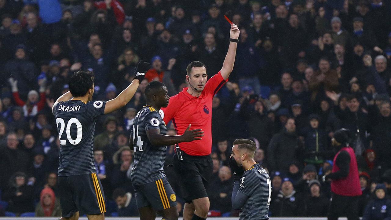 Leicester City's James Maddison, kneeling, is shown a red card