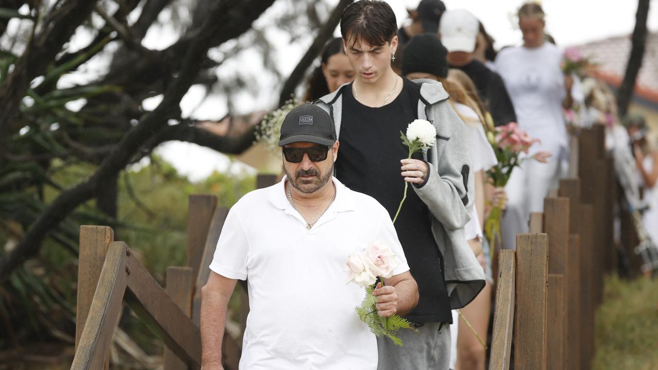 Father Michael Stewart leads friends and family to the beach tribute of 16-year-old alleged stabbing victim Balin Stewart on his home beach at Buddina. Picture: Lachie Millard