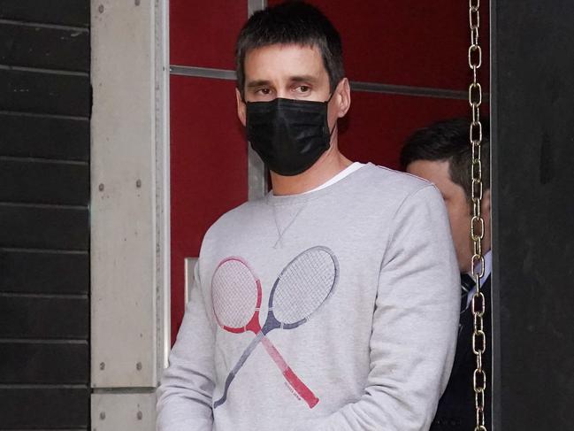 Richard Pusey, the driver of a Porsche who allegedly fled the scene of a truck crash on Melbourne's Eastern Freeway which killed four police officers, is taken away from his Fitzroy property by police in Melbourne, Thursday, April 23, 2020. (AAP Image/Michael Dodge) NO ARCHIVING