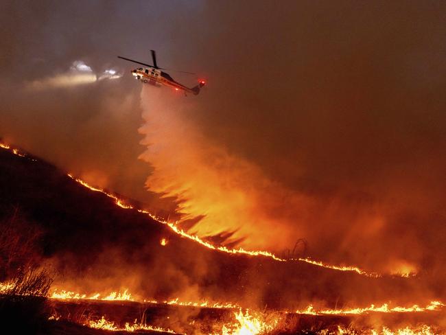 Water is dropped by helicopter on the Kenneth Fire in the West Hills section of Los Angeles. Picture: AP Photo/Ethan Swope