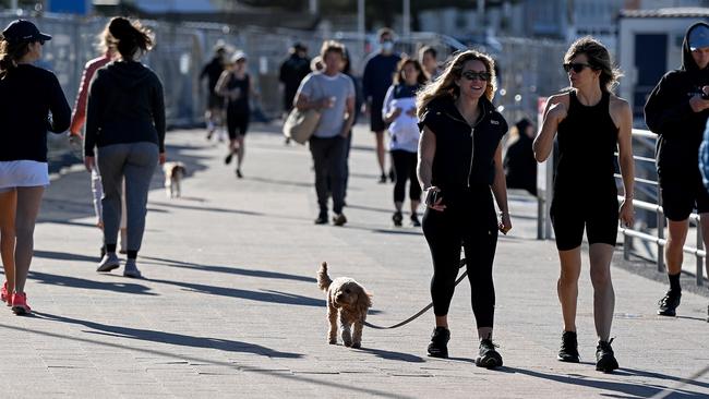 People walk maskless along the foreshore at Bondi Beach in Sydney where transmission between households has been difficult to prevent. Picture: NCA NewsWire/Bianca De Marchi