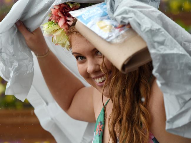 Racegoers shelter from the rain.  Melbourne Cup races, Flemington Racecourse.  Picture: Nicole Garmston