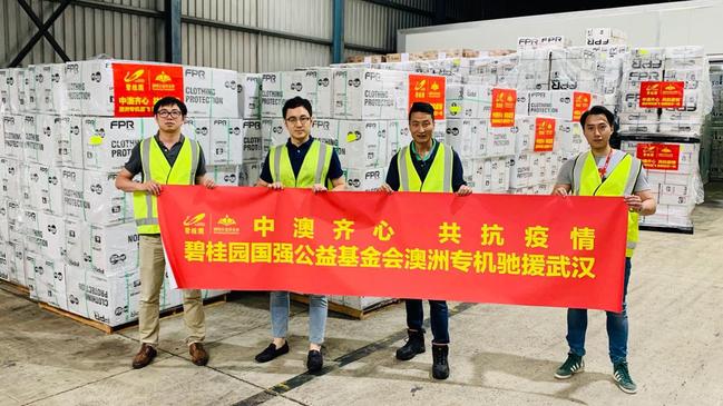 Workers from Risland Australia stand next to some of the 90 tonnes of surgical masks and other equipment destined for the Chinese city of Wuhan. Picture: LinkedIn