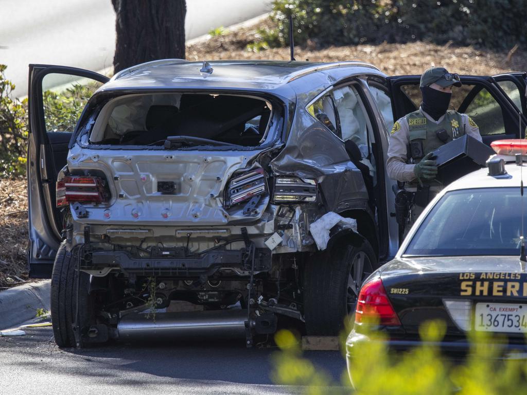 Los Angeles County Sheriff deputies gather evidence from the car that golf legend Tiger Woods was driving.