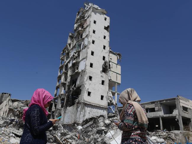 Girls in Gaza search for Pokemon under the rubble of houses destroyed by Israel in the 2014 war. Picture: Getty