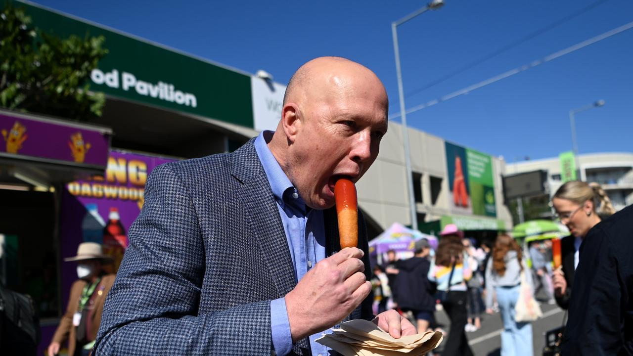 Federal Leader of the Opposition Peter Dutton eats a Dagwood Dog as he visits the Ekka show at the RNA Showgrounds. Picture: Dan Peled