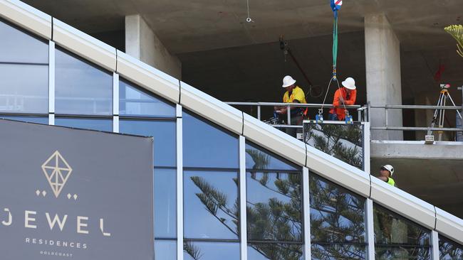 Workmen at the Jewel development at Broadbeach pictured during the glass installation. Picture Mike Batterham