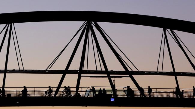 Bicycle riders and pedestrians cross the Goodwill Bridge.