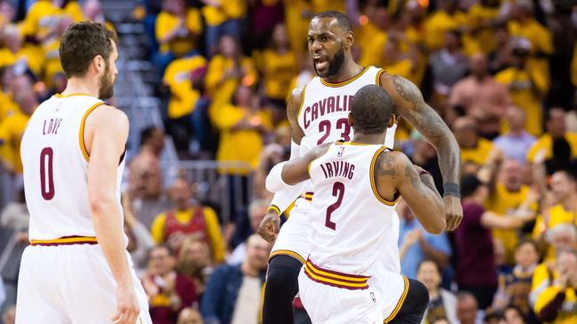 LeBron James celebrates with Kyrie Irving and Kevin Love during Cleveland’s win over Toronto.