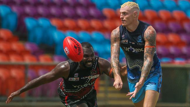 Mitch Robinson gets the ball away under pressure from Michael Coombes in the round 12 NTFL match between Tiwi Bombers and Darwin Buffaloes at TIO Stadium. Picture: Glenn Campbell