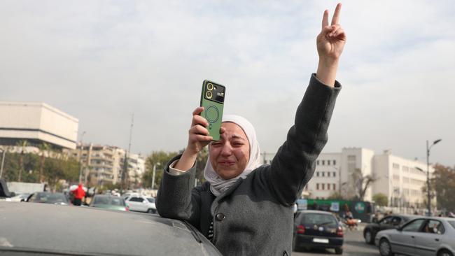 A woman celebrates the fall of the Syrian regime in Umayyad Square in Damascus.