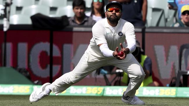 India's Ravi Ashwin takes a catch to dismiss Australia's Usman Khawaja during the first cricket test between Australia and India in Adelaide, Australia,Sunday, Dec. 9, 2018. (AP Photo/James Elsby)