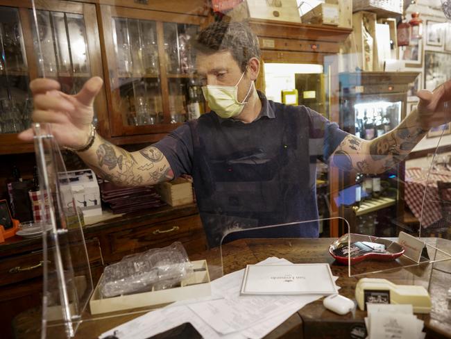 A technician holds up a plexiglass barrier as a possible solution for preventing the spread of COVID-19 virus. Picture: AP