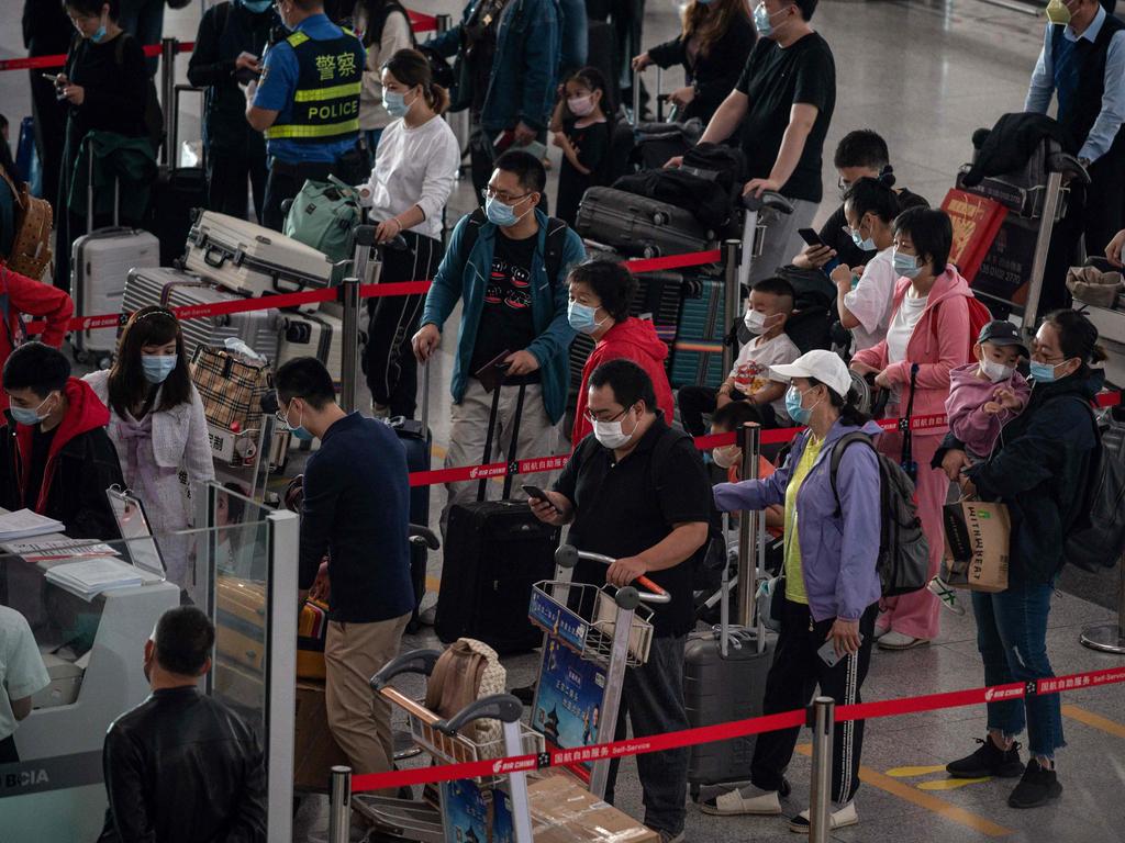 People queue to check in for domestic flights at Beijing's Capital International Airport on September 30. Picture: Nicolas Asfouri/AFP