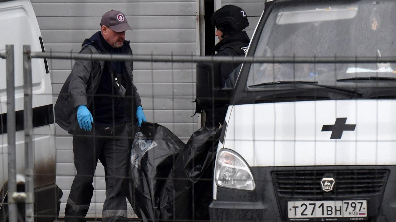 Law enforcement officers carry out a victim’s body on Saturday. Picture: AFP