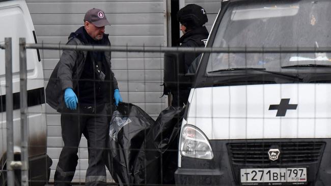 Law enforcement officers carry out a victim’s body on Saturday. Picture: AFP