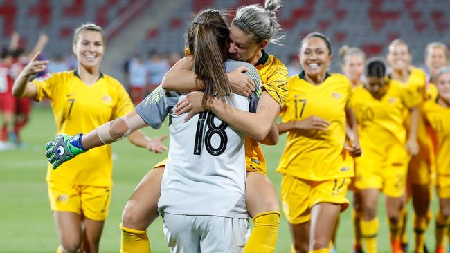 Australia's defender Alanna Kennedy (C) hugs teammate goalkeeper Mackenzie Arnold after defeating Thailand on penalties during the AFC Women's Asian Cup Semi Final match between Australia and Thailand at the King Abdullah II Stadium in the Jordan city of Amman on April 17, 2018. Australia defeated Thailand 3-1 in penalties after a 2-2 draw after full time. / AFP PHOTO / JACK GUEZ