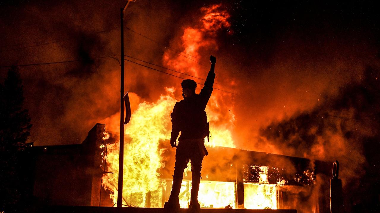 A protester stands in front of a burning building set on fire during a demonstration in Minnesota over the death of George Floyd. Picture: Chandan Khanna/AFP