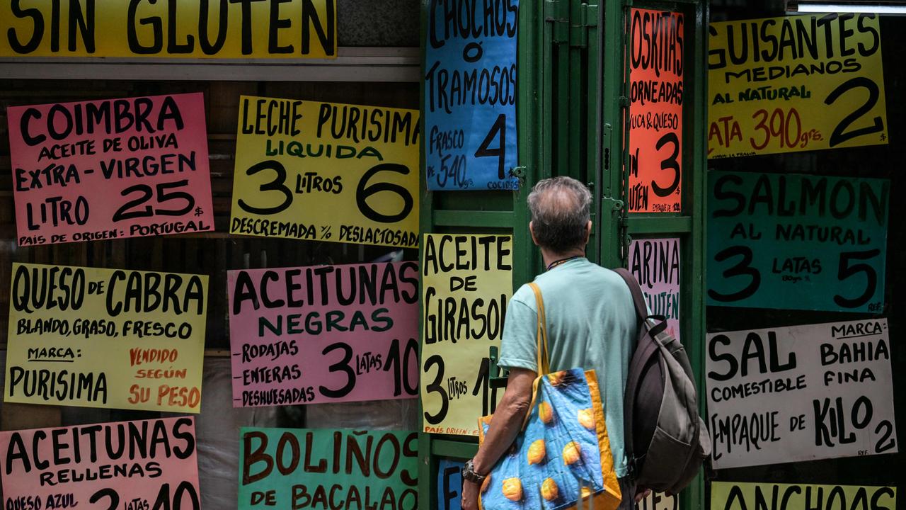 Areas such as Caracas, pictured here were man observes food prices, has been listed as one of the more concerning areas for visitors. Picture: Juan BARRETO / AFP.