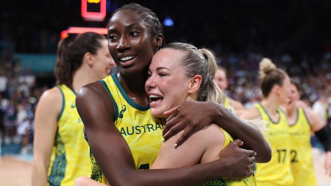 LILLE, FRANCE - AUGUST 04: Ezi Magbegor #13 hugs Tess Madgen #7 of Team Australia hug after their team's win against France during a Women's basketball Group Phase - Group B game between Australia and France on day nine of the Olympic Games Paris 2024 at Stade Pierre Mauroy on August 04, 2024 in Lille, France. (Photo by Gregory Shamus/Getty Images)