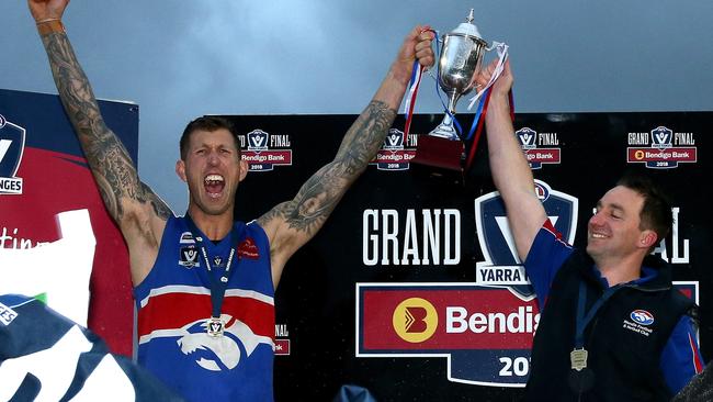 Robbie Ross and then-Wandin coach Nick Rutley raise the cup in 2018. Ross spent 2013-18 at the club for two flags.