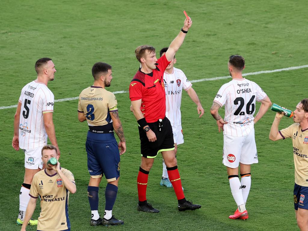 Roar midfielder Jay O'Shea (26) is sent off by referee Daniel Cook. Picture: Matt King/Getty Images