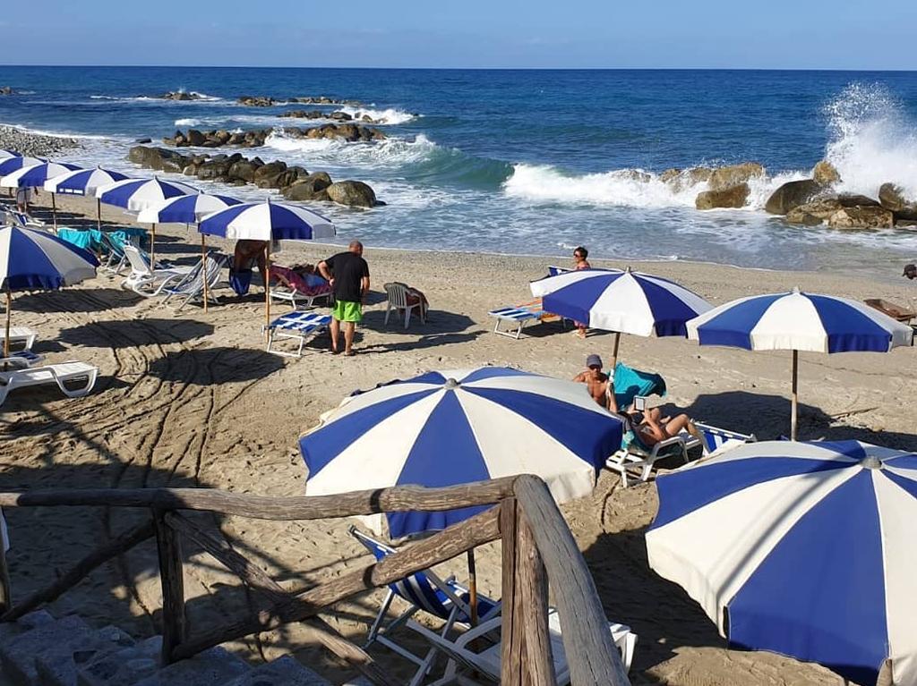 As the volcano sits above, tourists lap up the sun on the beaches below.