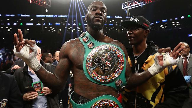 Deontay Wilder poses with trainer Marc Breland after knocking out Luis Ortiz in the tenth round of their WBC Heavyweight Championship fight.