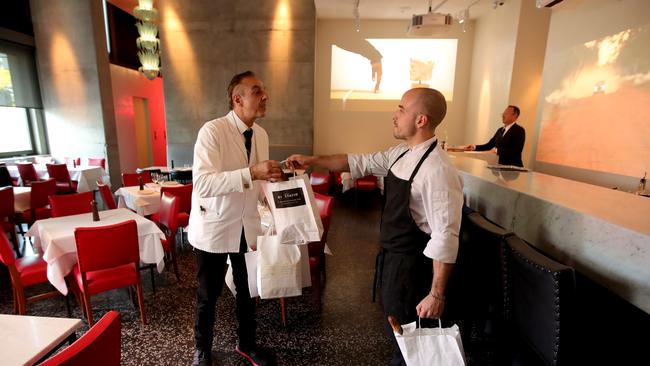 Di Stasio Citta Chef Emanuele Cipollini (right) hands over a delivery order to waiter Marco Sellitto. Picture: Stuart McEvoy/The Australian.