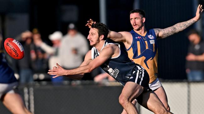 WRFL: Hoppers Crossing’s David Barbieri fires off a handball. Picture: Andy Brownbill