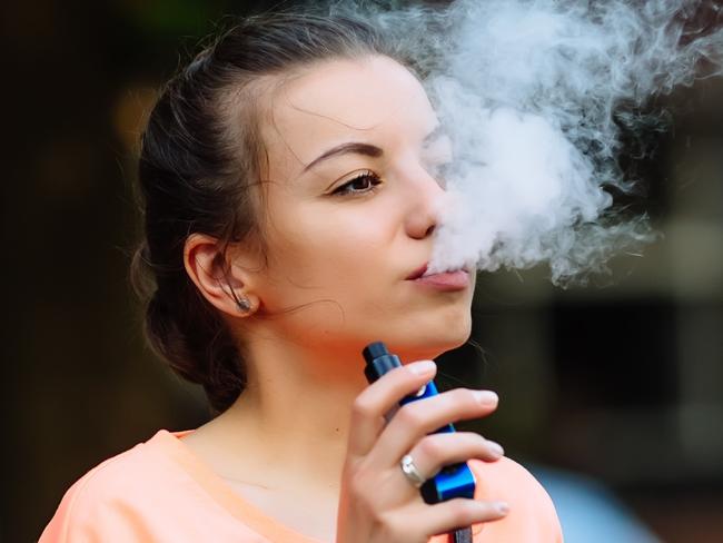 Pretty young girl vape popular ecig gadget,vaping device.Happy brunette vaper girl with e-cig.Portrait of smoker female model with electronic cigarette vaporizer.Ejuice vaping with fruit flavor liquid i STOCK IMAGE