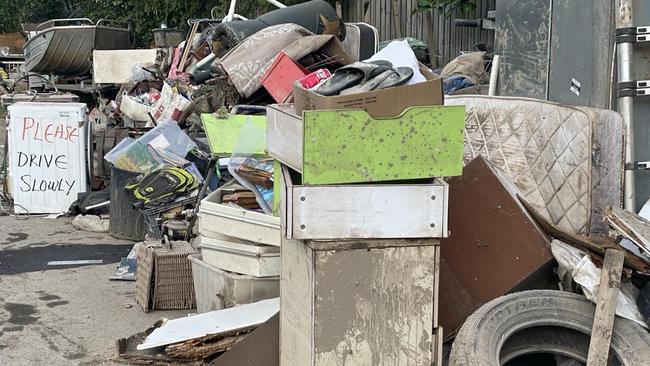 Ruined household goods pile up at Machans Beach with the clean up underway. Picture: Bronwyn Farr