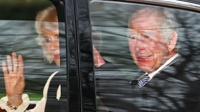 TOPSHOT - Britain's King Charles III and Britain's Queen Camilla wave as they leave by car from Clarence House in London on February 6, 2024. King Charles III's estranged son Prince Harry reportedly arrived in London on Tuesday after his father's diagnosis of cancer, which doctors "caught early". (Photo by HENRY NICHOLLS / AFP)